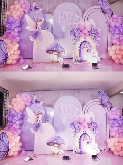 A magical fairy and butterfly theme in shades of lavender and pink. This enchanting setup includes a fairy house, mushroom props, and delicate butterfly details.