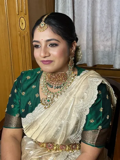 A beautiful, elegant look for a family member. This client is wearing a green and gold half-saree, her makeup kept soft and glamorous to enhance her natural features.