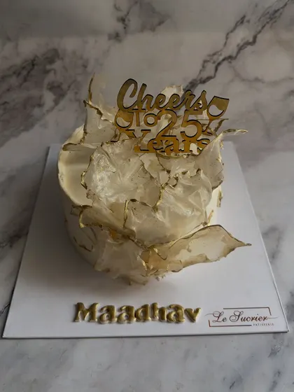 A modern and artistic birthday cake featuring abstract, translucent wafer paper sails with delicate gold-painted edges.