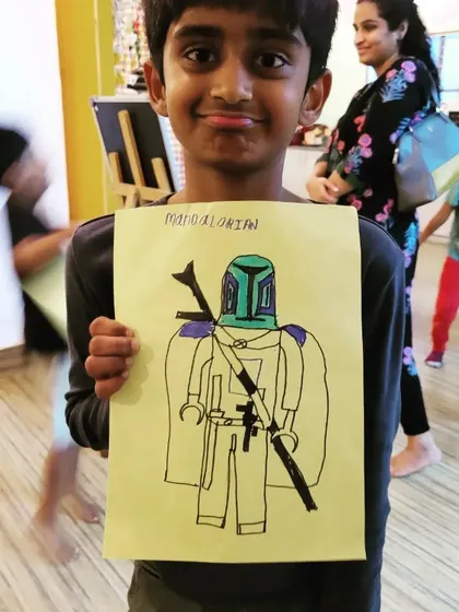 This young man is so proud of his Mandalorian drawing! We love seeing kids bring their favorite characters to life, mixing pop culture with our folktales for a truly creative session.