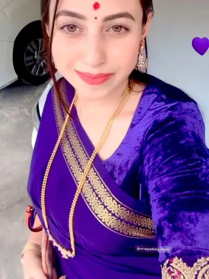 A client selfie showing off her rich purple velvet blouse. It's a simple yet luxurious choice that pairs beautifully with her purple saree.