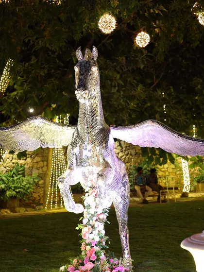 The mirrored Pegasus statue illuminated at night, creating a magical and fantastical focal point.