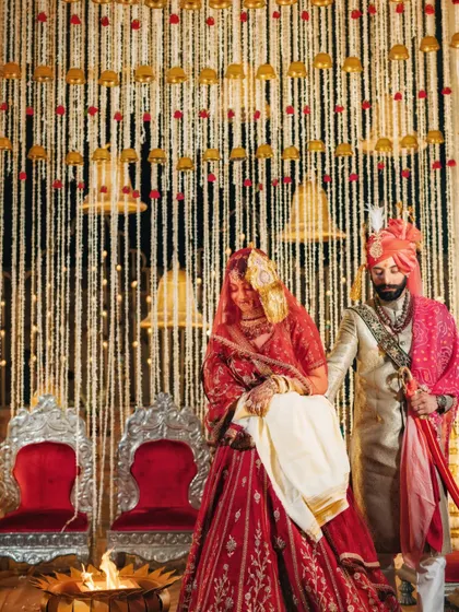 The bride and groom taking their pheras around the sacred fire, a timeless ritual in a royal Marwar setting.