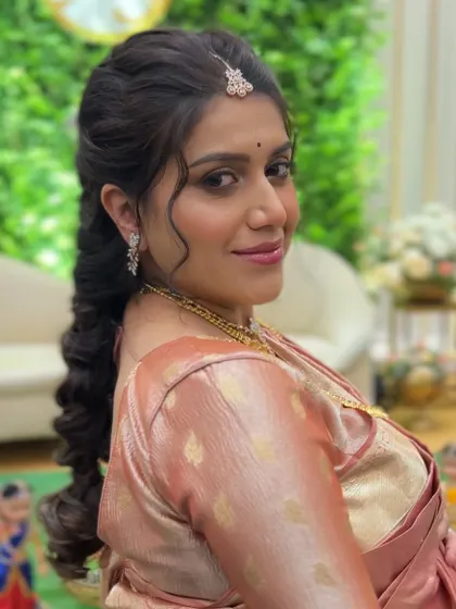 A radiant mom-to-be at her baby shower. I draped this soft peach silk saree to be comfortable and elegant, with a side-swept braid that keeps the look fresh and pretty.