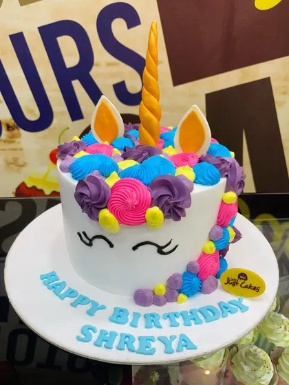 A 2.5kg unicorn cake with a vibrant, multi-colored buttercream mane.