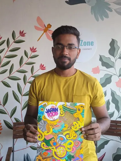 A participant with his finished coloring page, a vibrant illustration of Japanese food.