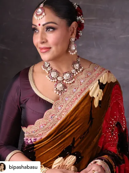 A beautiful three-quarter portrait of Bipasha Basu, highlighting her graceful pose and the rich colors of her outfit.