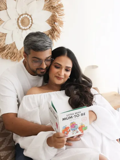 Preparing for their new role with love and a little bit of fun. Reading a 'Mum-to-be' book together is a sweet, playful moment that adds personality to their session.