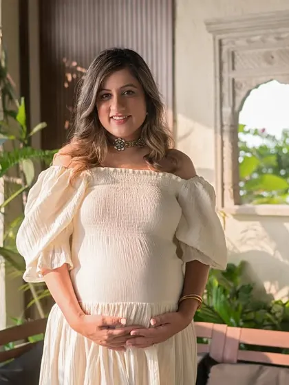 A stunning portrait of the expecting mother on her balcony, surrounded by greenery. This image perfectly blends the beauty of pregnancy with the natural elements of her home environment.