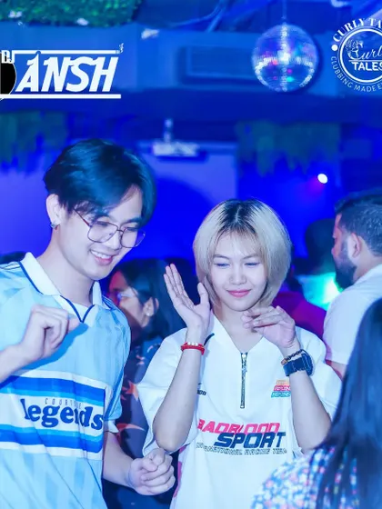 A couple enjoying a dance together, lost in the blue lights of the club.