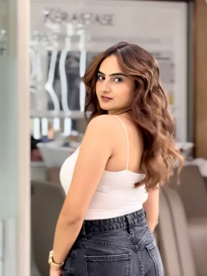 A beautiful shot of a finished caramel balayage. The soft waves perfectly showcase the seamless blend of colors and the healthy shine of the hair.