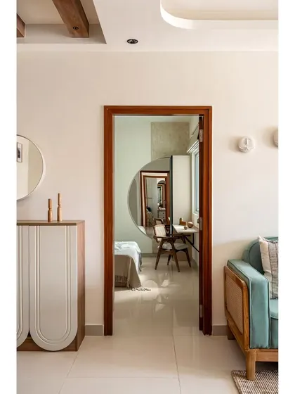 A view from the living room of 'The Boho Escape' into the guest bedroom, showing how I create visual connections between spaces using sightlines and reflective surfaces like mirrors.