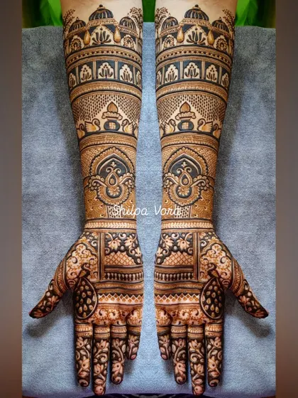 A full-arm bridal design with architectural elements and traditional motifs, creating a regal and timeless look.