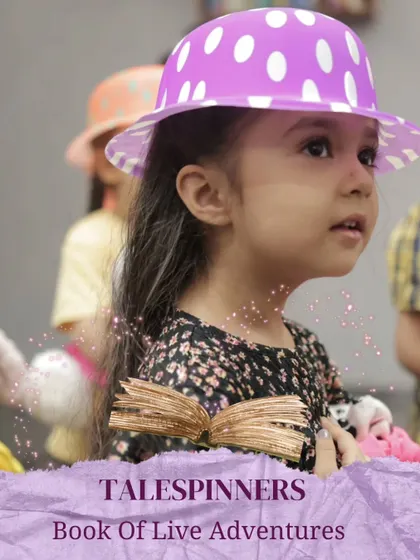 A young girl in a polka-dot hat, fully engaged in our "Talespinners: Book of Live Adventures" program.