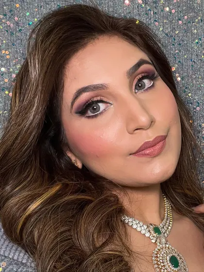 A detailed shot of the eye makeup, which features a classic winged liner and blended smokey shadow. This is paired with soft waves for a balanced look.