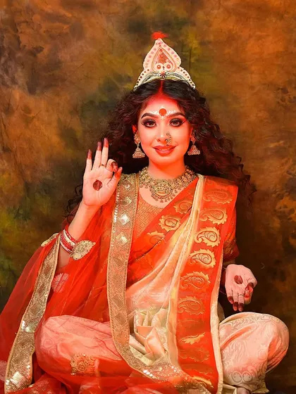 The model posing with a hand gesture of blessing, embodying the grace and power of the goddess.
