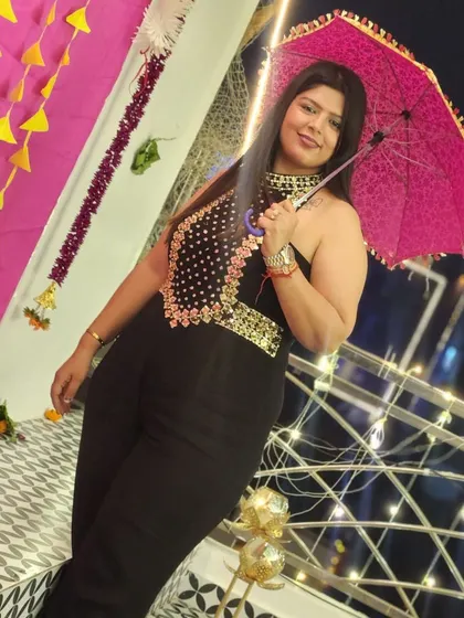 A client posing with a pink umbrella in her black embellished jumpsuit. This outfit is perfect for a Diwali card party or any festive night out.