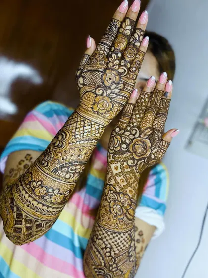 A beautiful pose from the bride, showing off her full bridal henna and pretty pink nails.