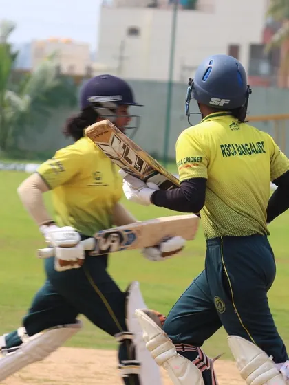 A mid-pitch moment between two running batters, capturing the energy of the game.