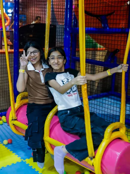 Best friends enjoying the swinging log ride together. It's a great spot for kids to team up and have fun during a party.