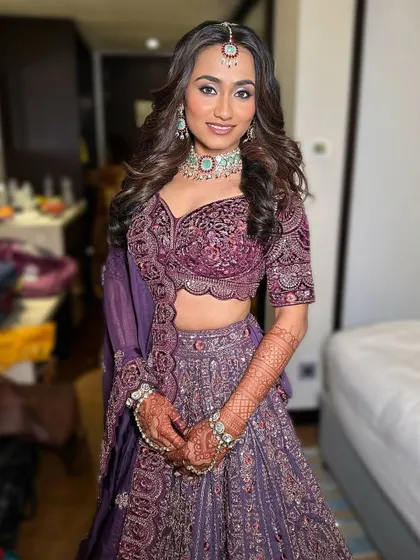A full-length shot of the bride in her purple rental lehenga, ready for her big event.