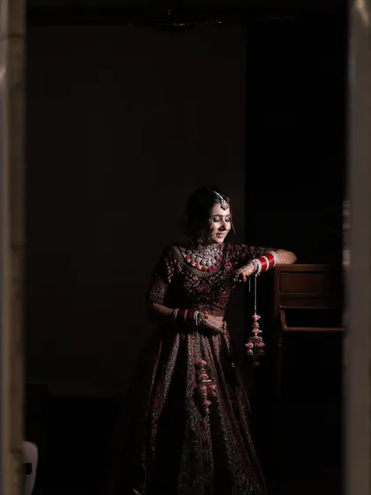 A quiet, reflective moment for the bride. The soft lighting enhances the gentle glow of her makeup.