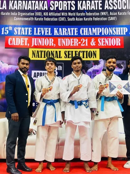 Our gold medal-winning team kata athletes proudly display their awards with their coaches.