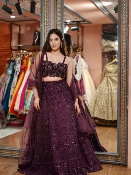 A full view of the glamorous deep purple lehenga. The contrast between the floral blouse and the sparkly skirt makes it a true statement piece.