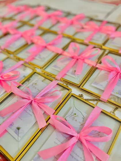 A large order of our brass photo frame favors, each personalized with a thank you note and a delicate necklace.