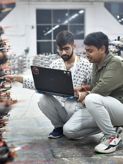 Two of our engineers collaborate, troubleshooting and programming the drones. This is a glimpse into the teamwork and problem-solving that happens on the ground to create a flawless show in the sky.
