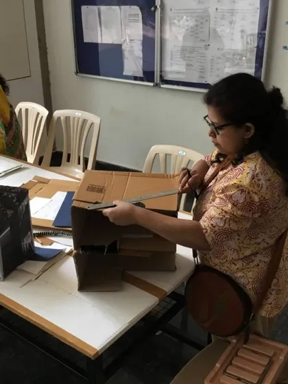 Volunteers work on turning cardboard and paper waste into useful items. We are always exploring new ideas for upcycling and reuse.