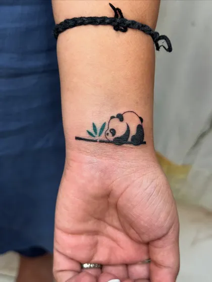 A small, charming tattoo of a panda, chosen by a client as her favorite animal. This piece was part of a larger session celebrating sisterhood, where each sister got tattoos that were personally meaningful.
