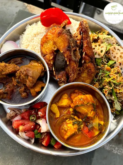 This is what a true Manipuri feast looks like. My non-veg thali is packed with variety, featuring fish curry, chicken curry, fried fish, a fresh lotus stem singju, and a simple tomato salad, all served with steamed rice.