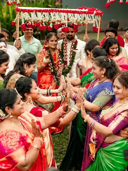 The bride and groom's procession, with female family members leading the way in a traditional welcome.