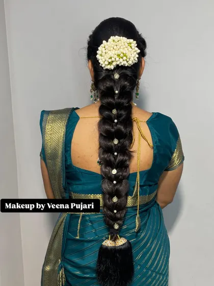 A classic long braid adorned with pearl accessories and a jasmine gajra. This is a simple, beautiful, and timeless choice for any traditional event.