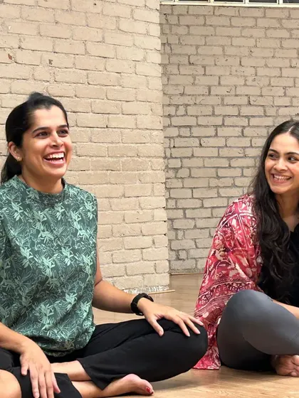 Two participants share a moment of laughter and connection during our Rewilding circle. Joy is a key component of our gatherings.