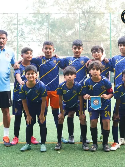 The U-13 team stands united with their coach before a match at The Winter Cup in Mumbai. Posing for a team photo is part of the pre-game ritual that builds unity and focus.