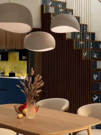 A view from the dining table towards the kitchen and staircase in HAUS 5, showing how the different design elements and materials flow into one another.