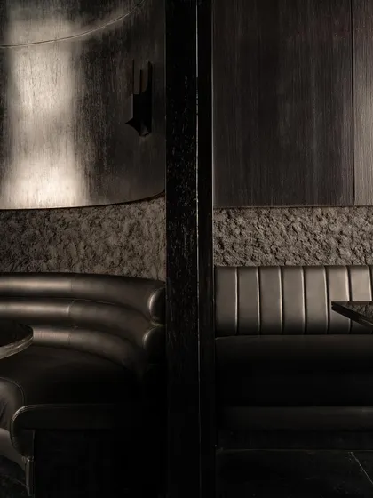 Details of the seating at Lair, where rough, rock-like textures meet smooth leather upholstery. This tactile contrast is central to the bar's sensory narrative.
