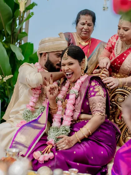 The fun and games of wedding rituals. This moment of laughter during a post-wedding game shows the playful spirit and strong bond between the couple and their families.