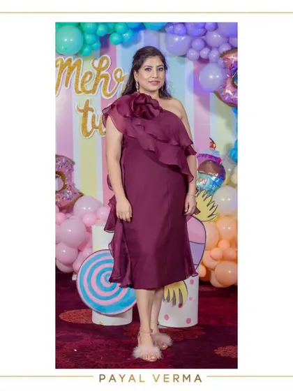 A client celebrating at a birthday party in our custom wine-colored one-shoulder ruffle dress. The organza ruffles add a touch of drama and sophistication to this elegant midi dress.