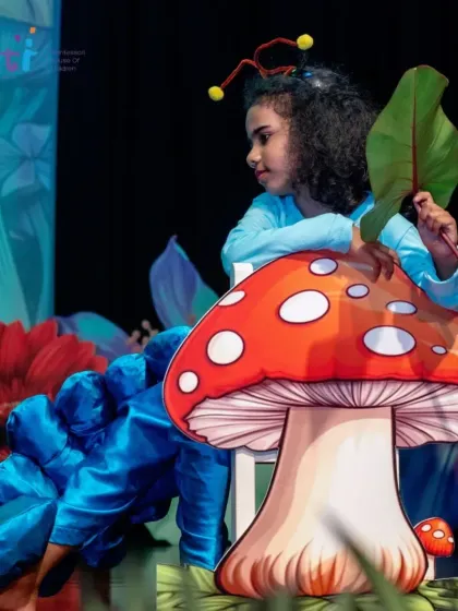 The cryptic Caterpillar sits atop a mushroom prop in a scene from "Alice in Wonderland." Our stage designs and props help bring these magical stories to life.