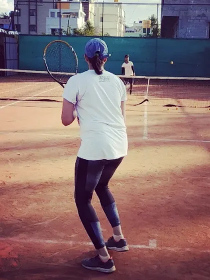 A player maintains a low center of gravity as she prepares to return a shot during a rally. Proper stance and readiness are key for effective defense and offense.