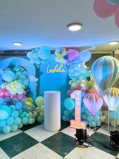 Up, up, and away! For Lashika's first birthday, we designed this dreamy hot air balloon themed decor. The pastel rainbow balloon arch and custom-printed backdrops created a whimsical sky for the little one's big day.