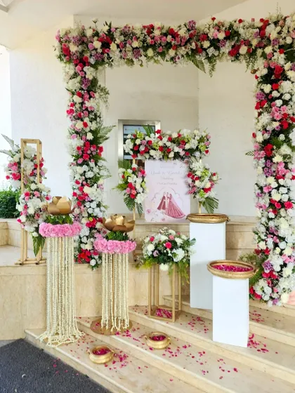 A beautiful setup on the steps of the venue, with a floral arch and traditional elements creating a perfect photo opportunity and welcome area.