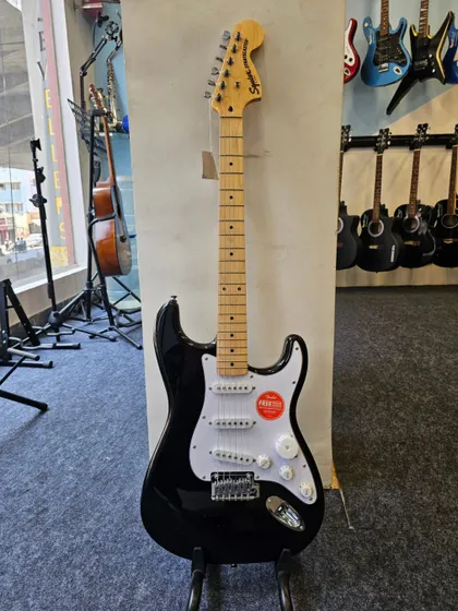 The Squier Affinity Stratocaster in black, a perfect starting point for any guitarist. This full-body shot showcases its timeless design, from the headstock down to the tremolo bridge.