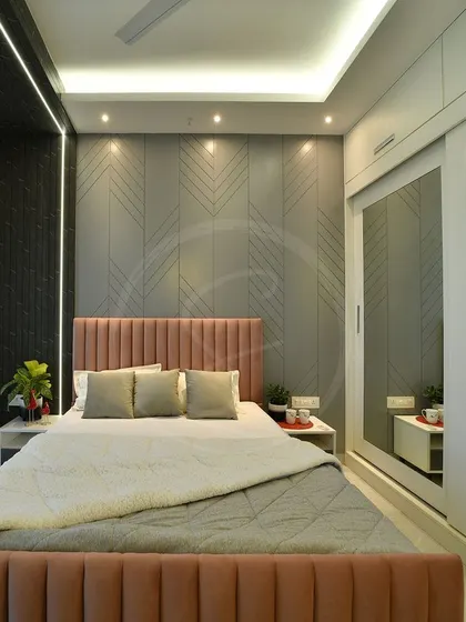 The actual photo of the completed bedroom, demonstrating the successful execution of the 3D design. The room features the pink bed, textured grey wall, and mirrored wardrobe as envisioned.