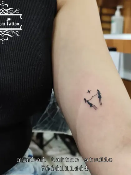 A tiny, minimalist tattoo of two figures holding hands under a star. This design is perfect for celebrating a special bond, like sisterhood or friendship, in a very subtle way.