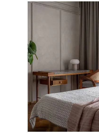 A quiet corner in a bedroom with a custom-designed writing desk. The textured wall panels and soft curtains create a peaceful and inspiring workspace.