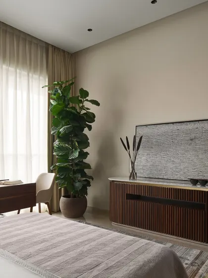 In the master bedroom, we designed an elegant console with fluted wood details and brass accents, which discreetly houses a music system. This piece combines refined glamour with modern technology.
